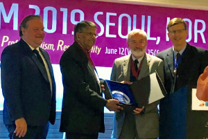 Dr. Holliman (second from right) receives the Gautam Bodiwala Lifetime Achievement Award at the 2019 IFEM conference.