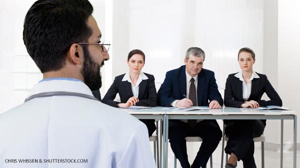 Young physician talking to a panel of interviewers.