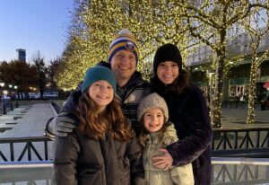 Dr. Janienne Kondrich smiles with her husband, Erik Jensen, and their daughters Ella and Evangeline.